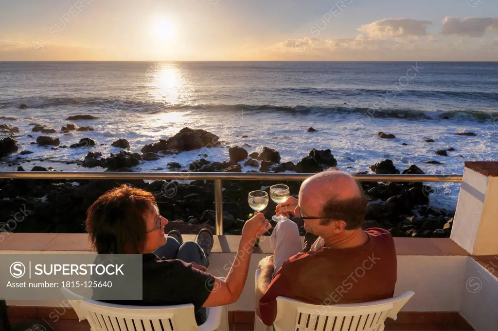 Spain, La Gomera, Mature couple sitting on terrace with white wine