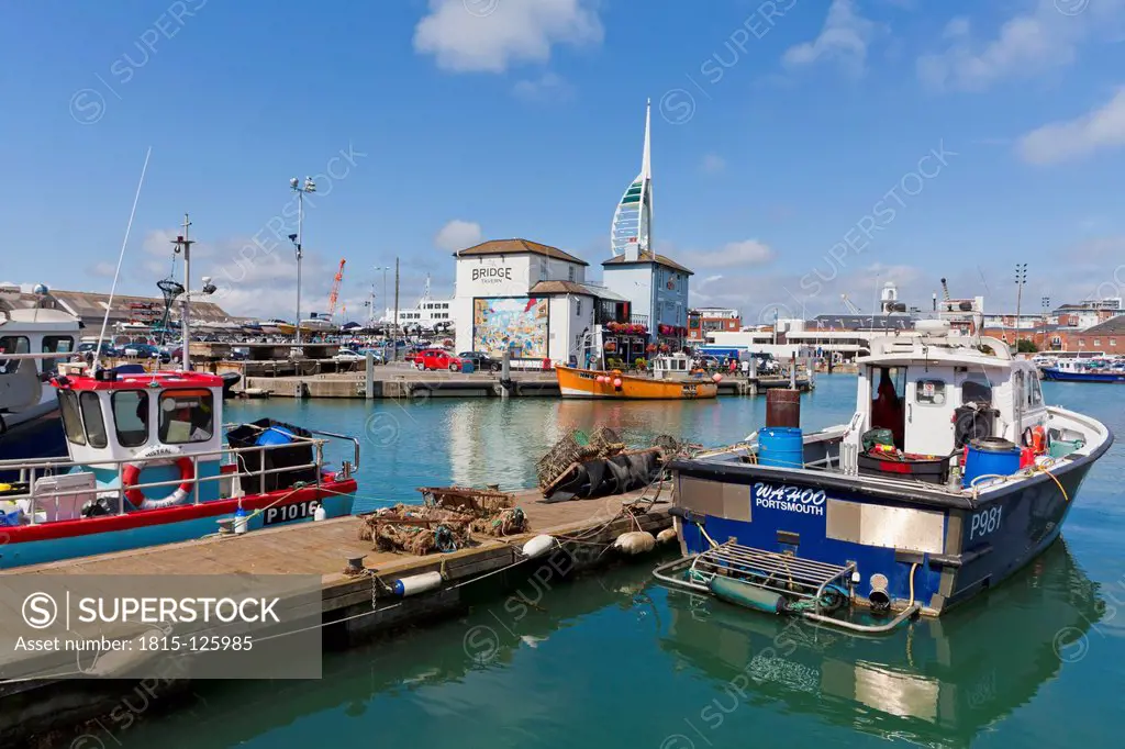 England, Hampshire, Portsmouth, View of fishing boats in harbour and Spinnaker Tower in background