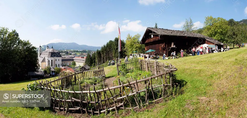 Austria, Cottage garden with museum, farmhouse and church in background