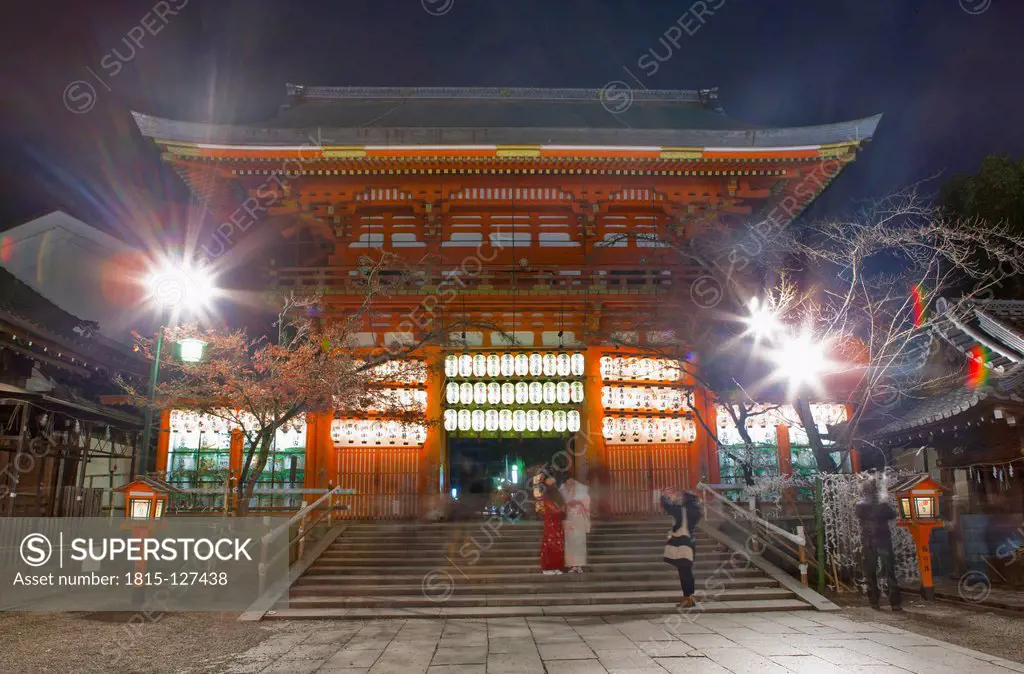 Japan, Kyoto, People taking photograph in temple at night