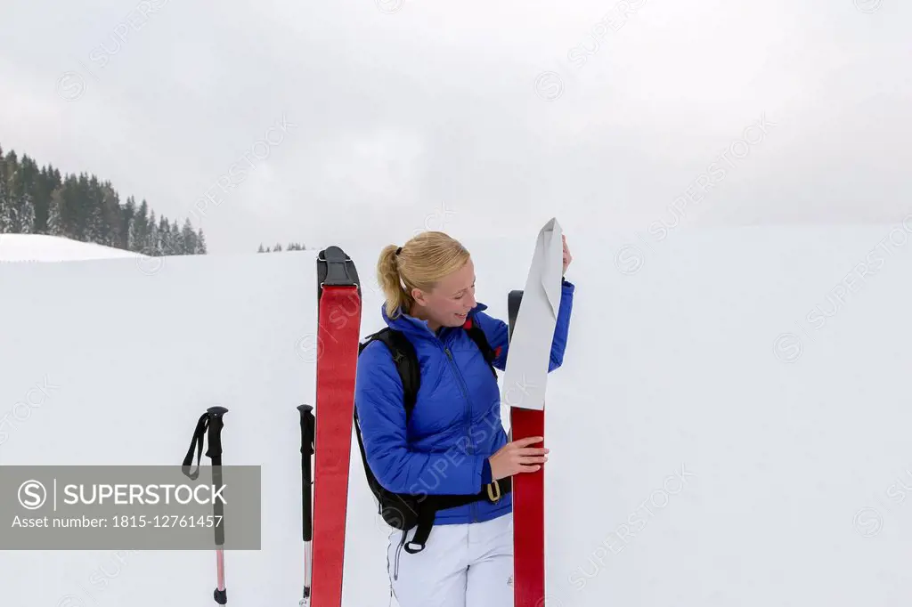 Woman prepating for ski tour, carrying avalanche ABS