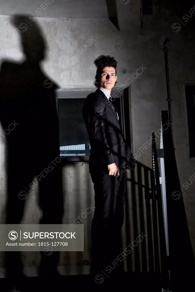 Germany, Bavaria, Young man standing in dark corner