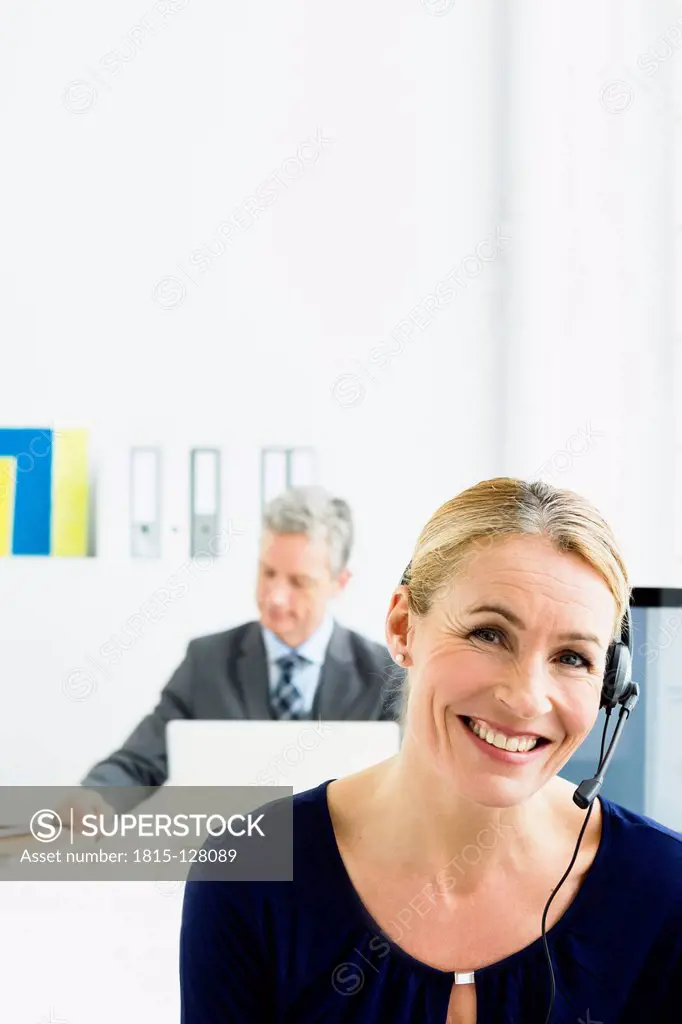 Germany, Businesspeople working in office, smiling