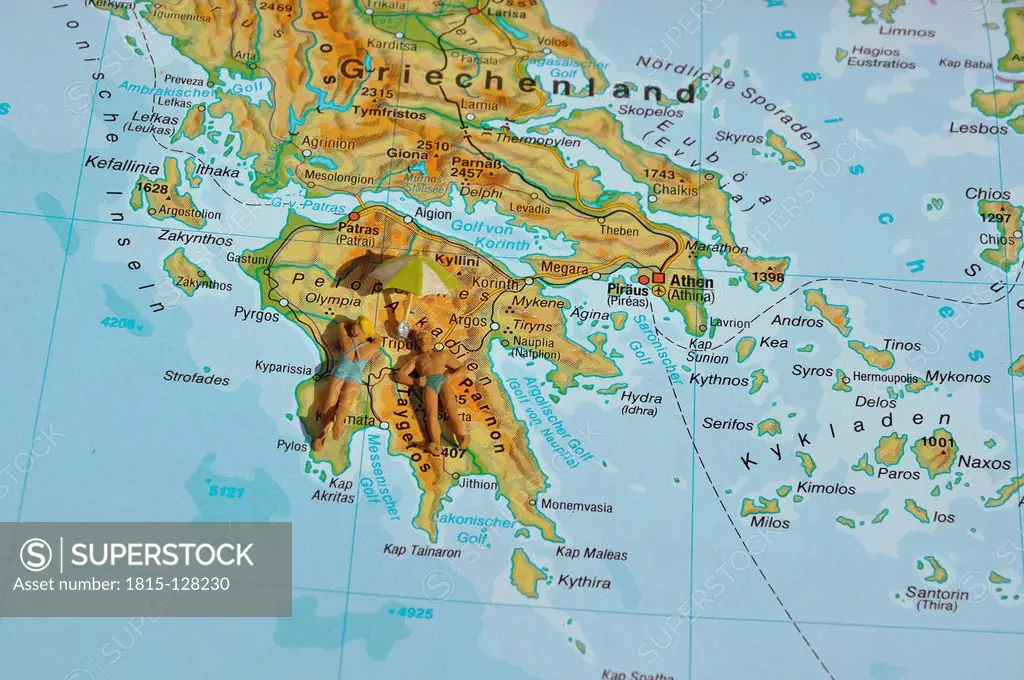 Greece, Couple of figurines laying on map