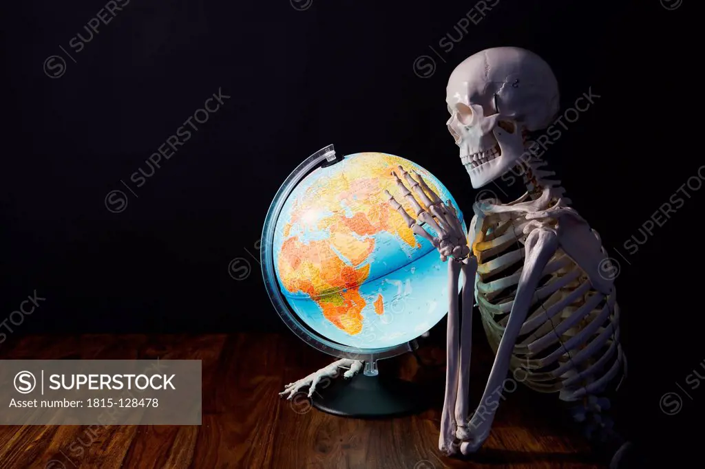 Skeleton holding globe
