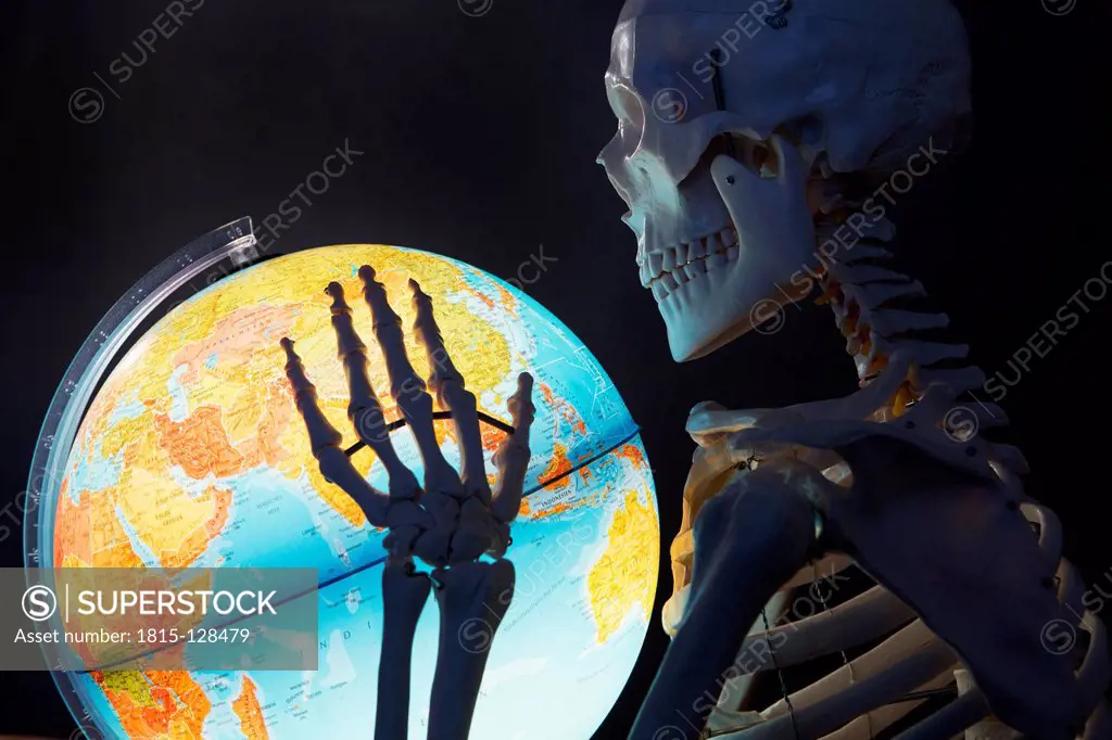Skeleton holding globe, close up