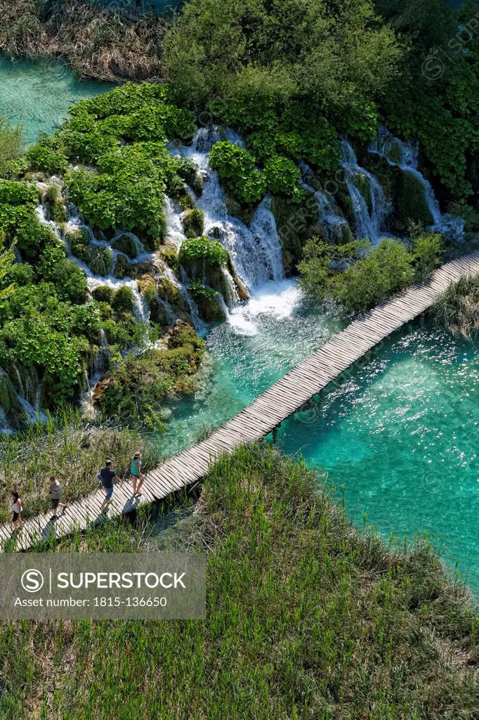 Croatia, Karlovac, Tourists walking on wooden footbridge