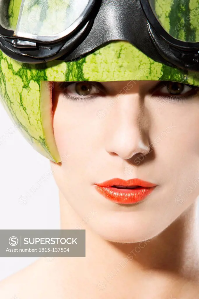 Portrait of young woman wearing watermelon helmet, close up