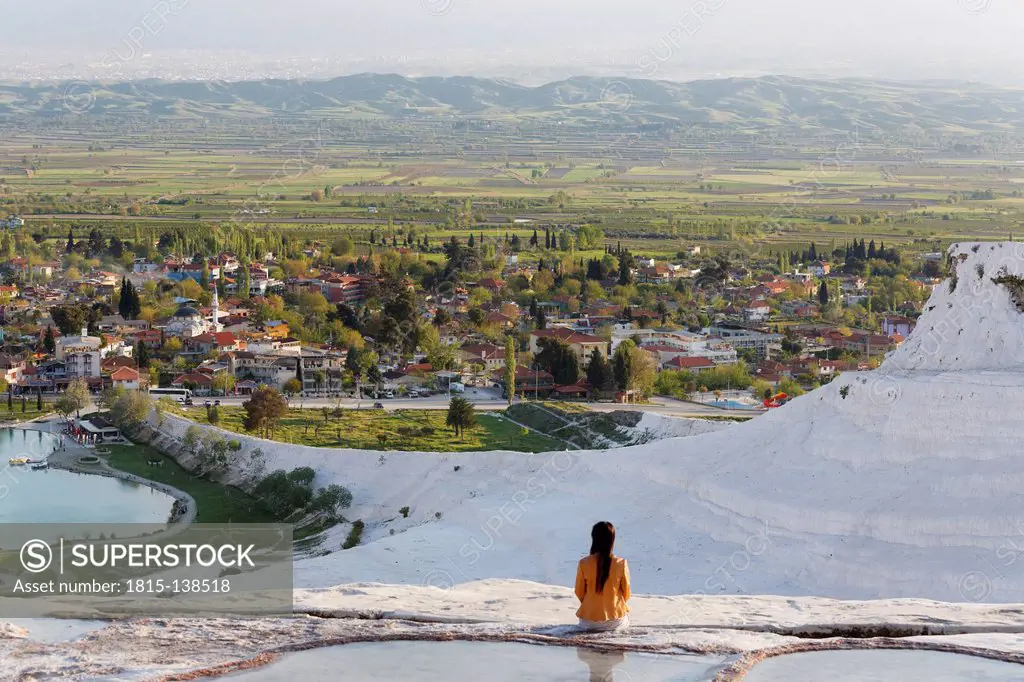 Turkey, View of woman sitting at Travertine terraces