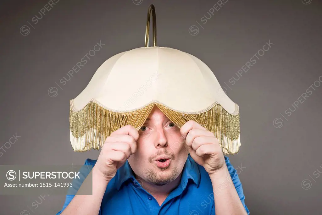 Portrait of mid adult man with electric lamp, close up