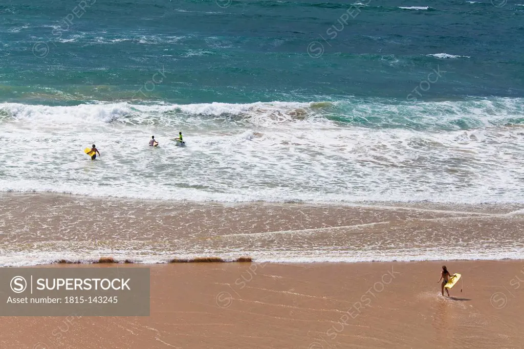 Portugal, Lagos, People playing with surfer at Praia do Amado beach