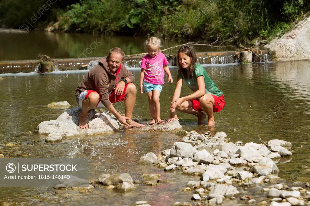 Germany, Bavaria, Chiemgau, Family at brook near Inzell