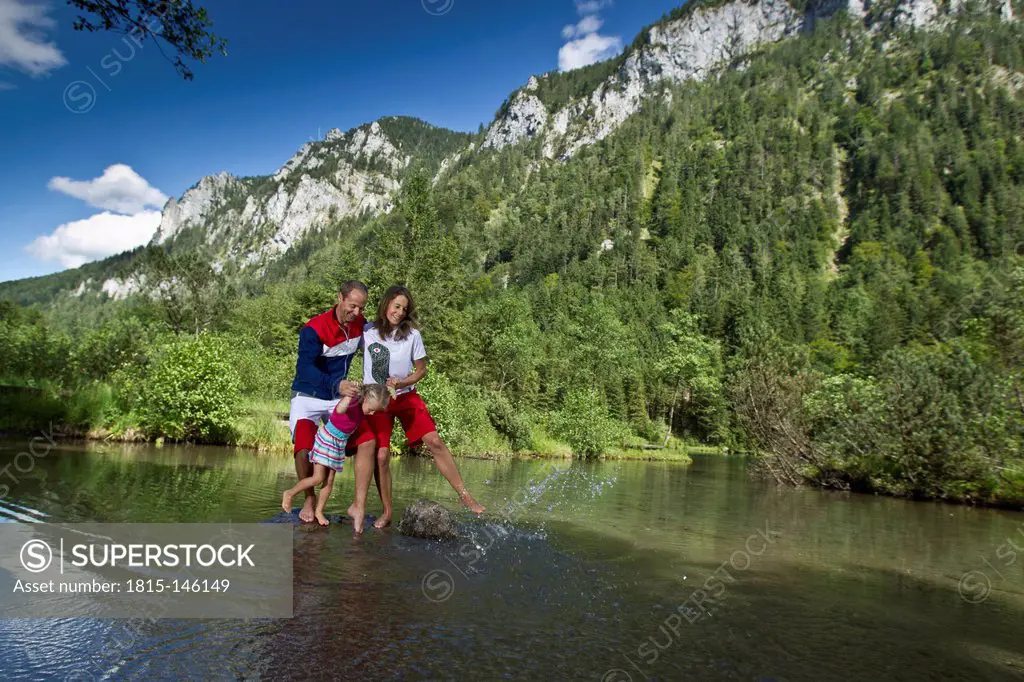 Germany, Bavaria, Chiemgau, Family crossing mountain lake