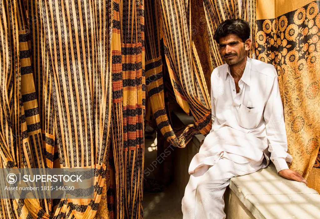 India, Rajasthan, Jodhpur, Man sitting on bench near dyeing factory
