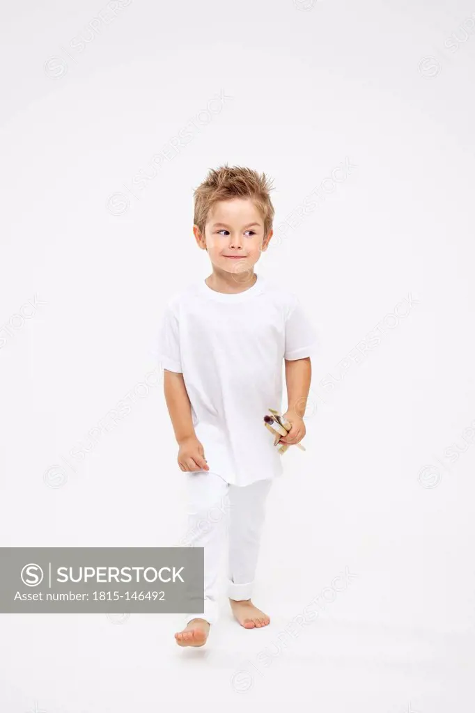 Toddler holding paint brushes
