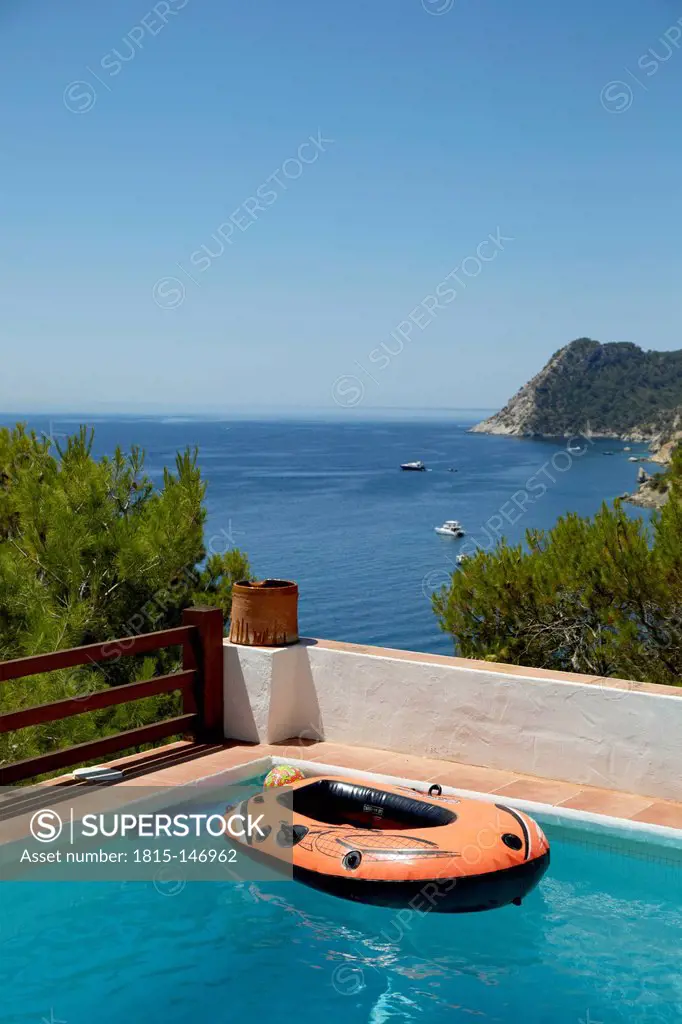 Spain, View of boat in swimming pool with mediterranean finca in background