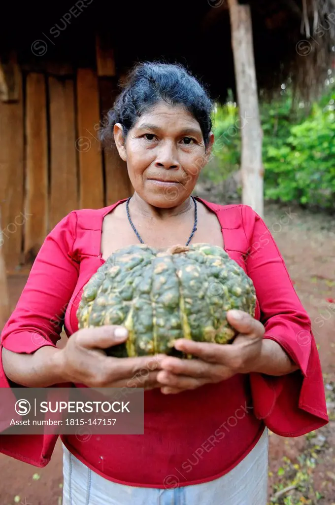Paraguay, Caaguazu, Woman of the Mbya-Guarani people holding pumpkin