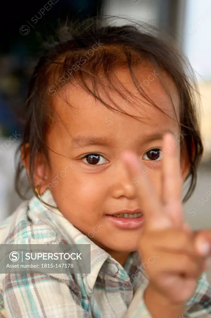 Cambodia, Takeo Province, Portrait of a little girl, making victory sign