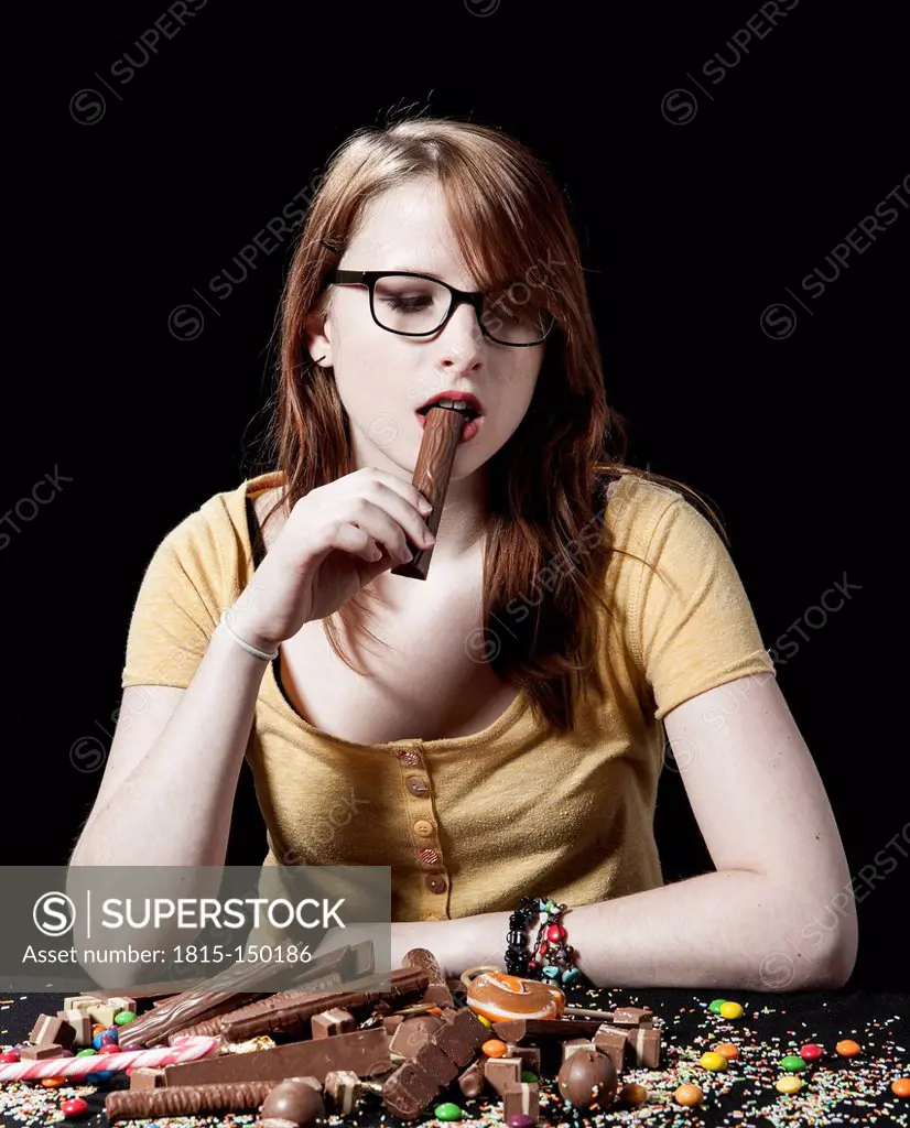 Young woman eating a chocolate bar