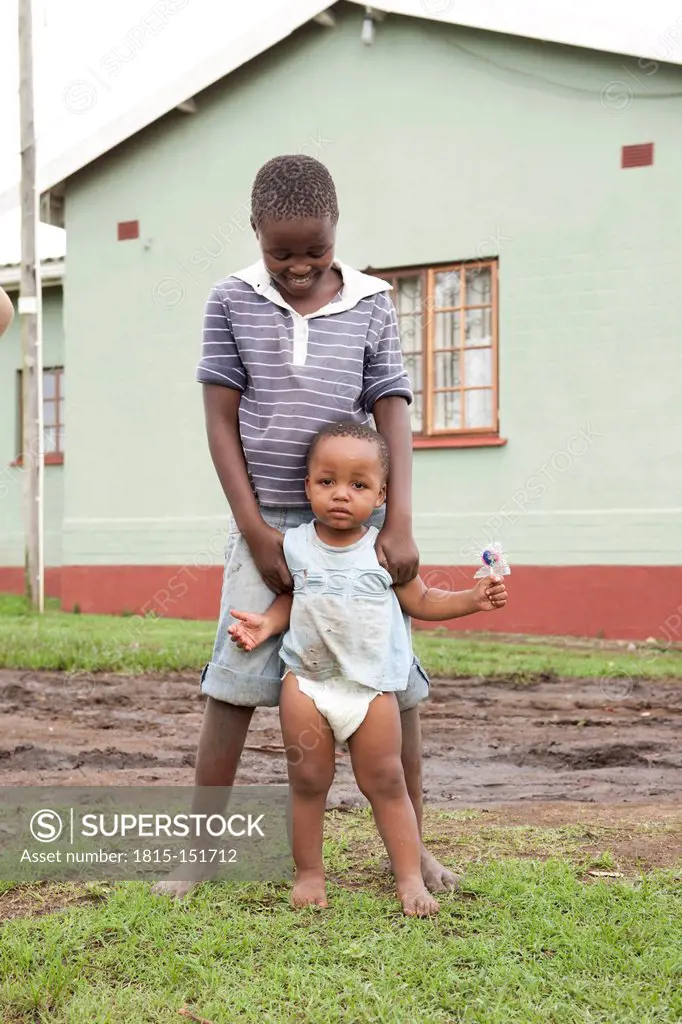 South Africa, KwaZulu-Natal, Eshowe, Boy with baby in front of a farm house