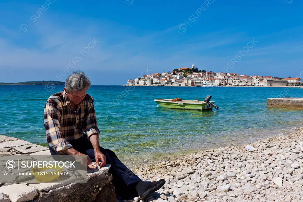 Croatia, Dalmatia, Primosten peninsula with fisherman