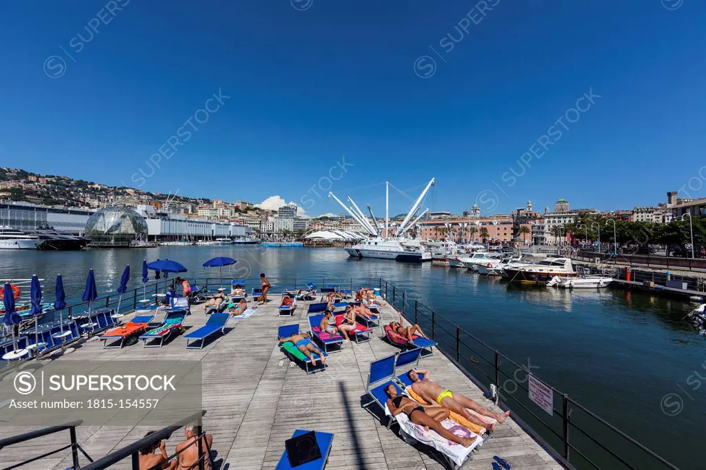 Italy, Genoa, View of Porto Ragerra with sun bathers on jetty