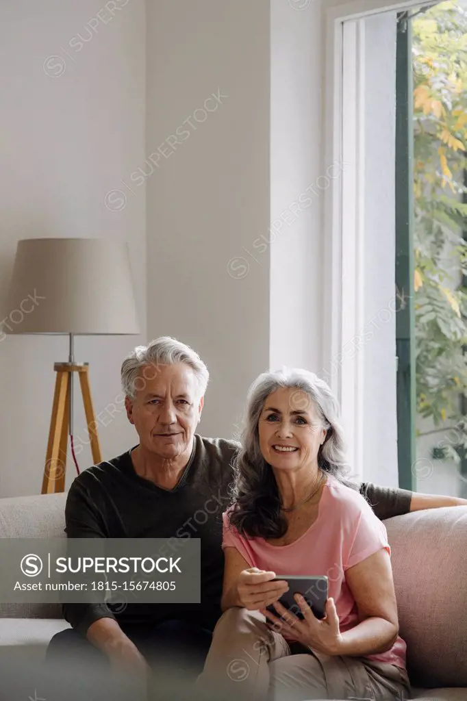Portrait of senior couple relaxing on couch at home