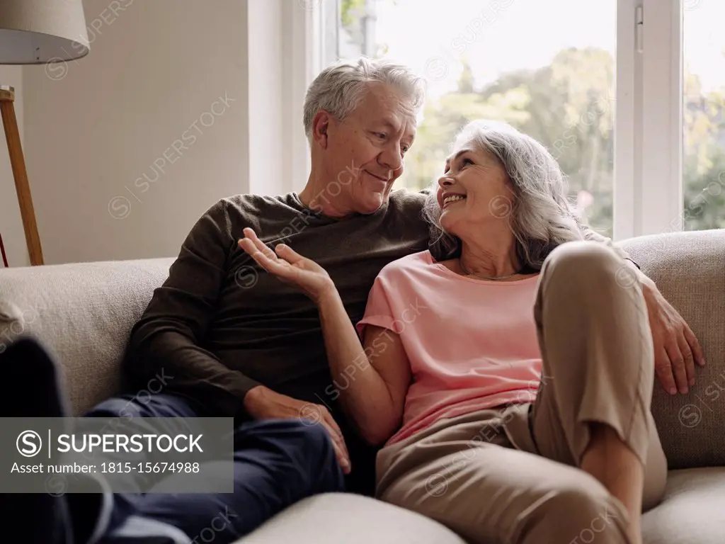 Happy senior couple relaxing on couch at home