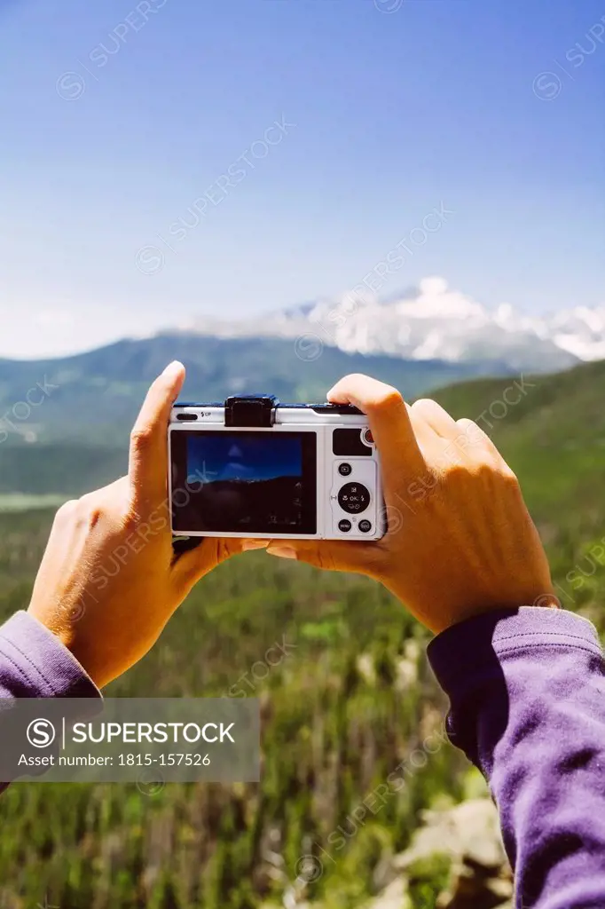 USA, Colorado, Rocky Mountain National Park, Woman taking a picture of Longs Peak and Mount Meeker