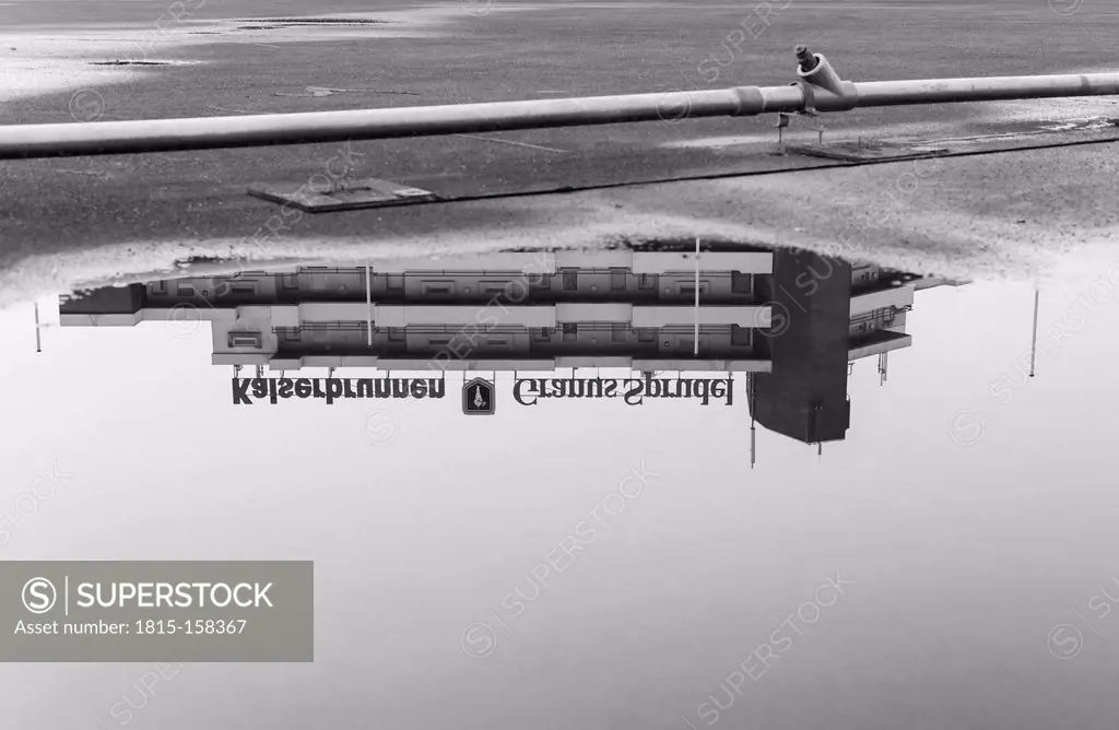 Germany, North Rhine-Westphalia, Aachen, Europaplatz, part of high-rise building reflecting at puddle