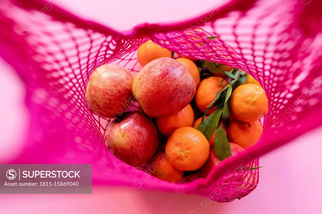 Fresh clementines and apples in eco-friendly reusable mesh bag