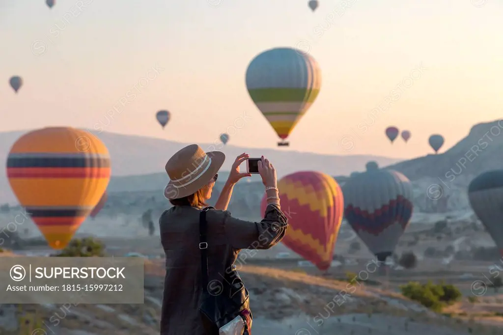 Young woman and hot air ballons, Goreme, Cappadocia, Turkey