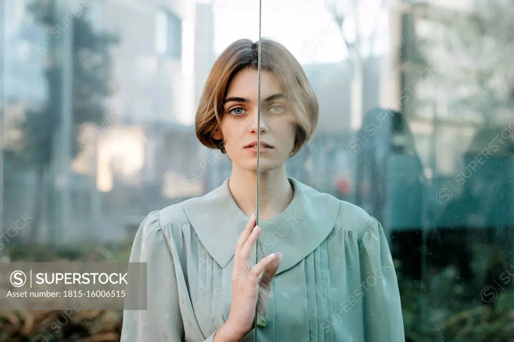 Portrait of woman with half of her face behind a glass