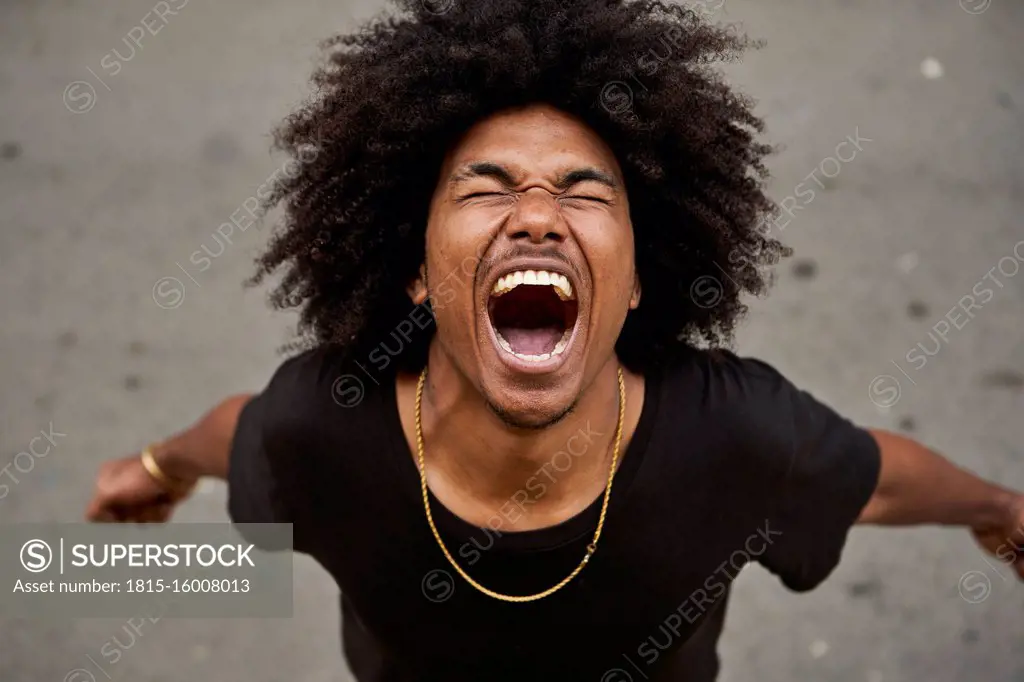Portrait of screaming young man with afro