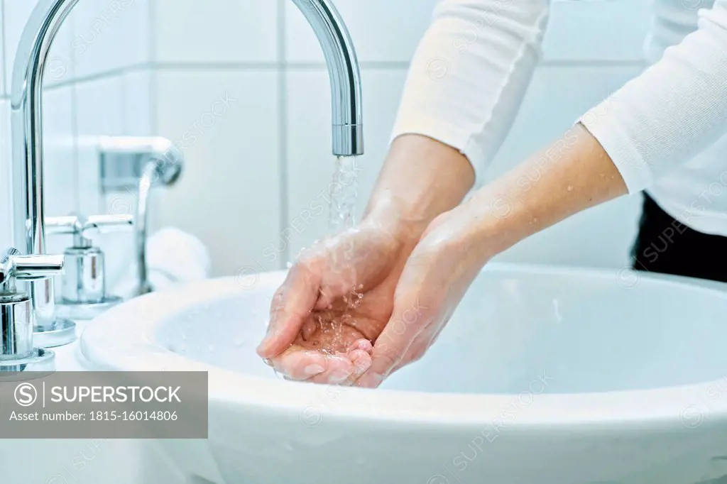 Woman washing her hand with soap