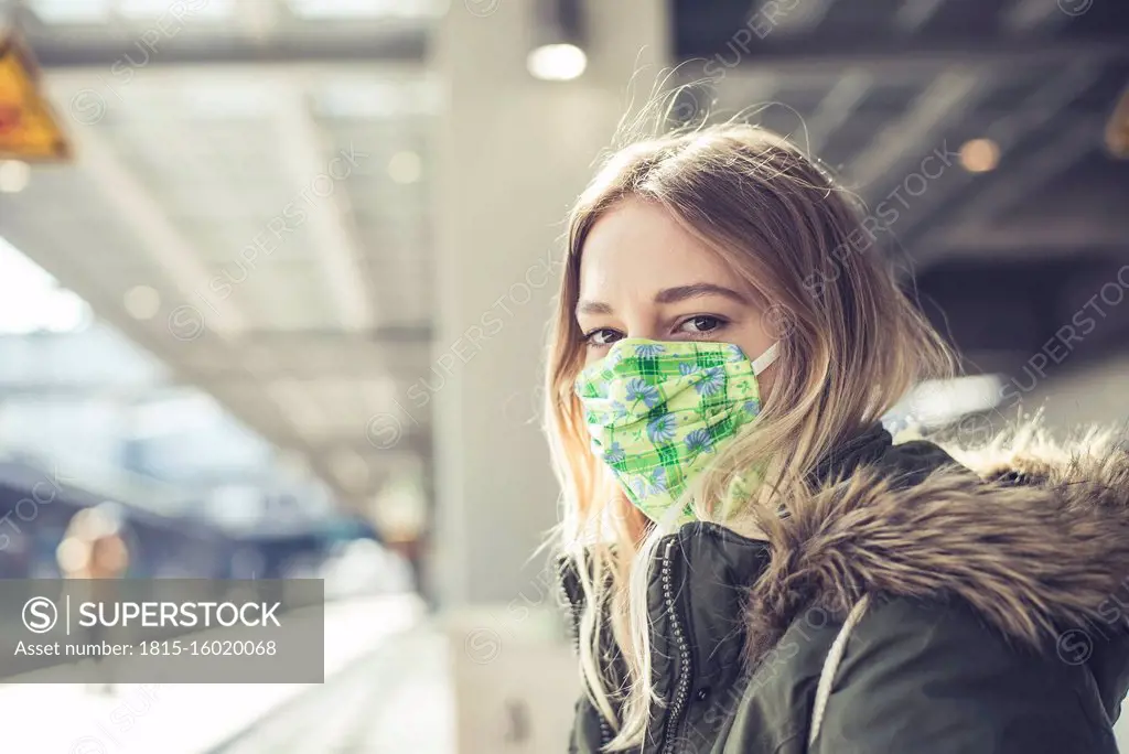 Portrait of young woman wearing mask at station platform