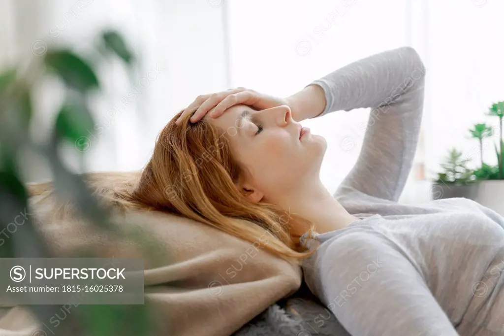 Serious young woman at home lying down