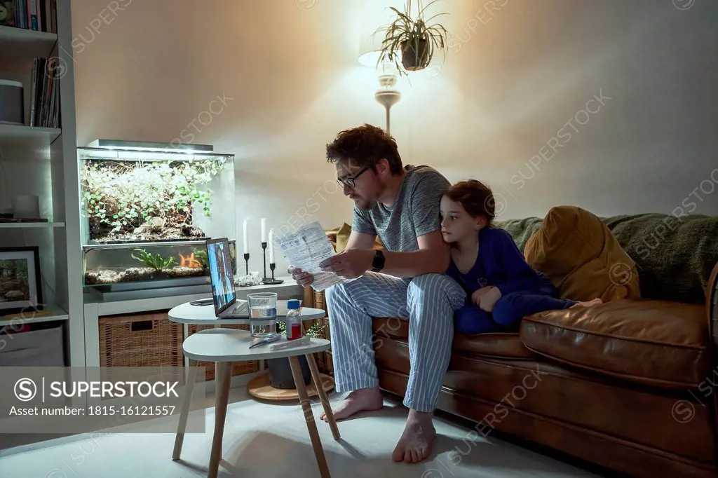 Sick girl sitting by father holding prescription while discussing with doctor over video call at home