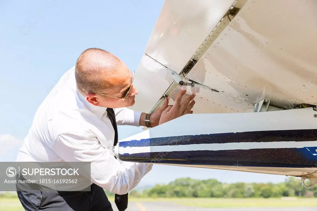 Pilot doing pre flight inspection on his sports plane