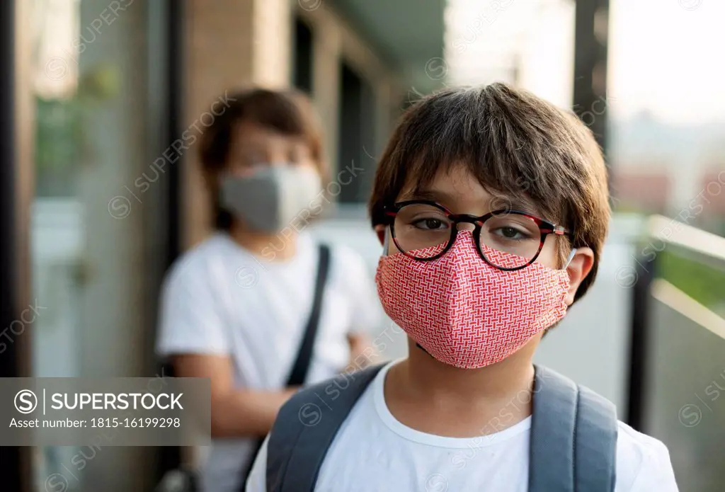 Siblings wearing masks outdoors