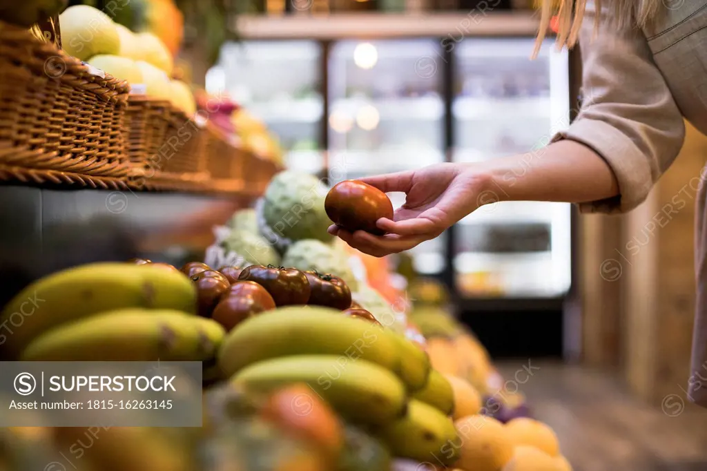 Cropped image of woman buying tomatoes at grocery store