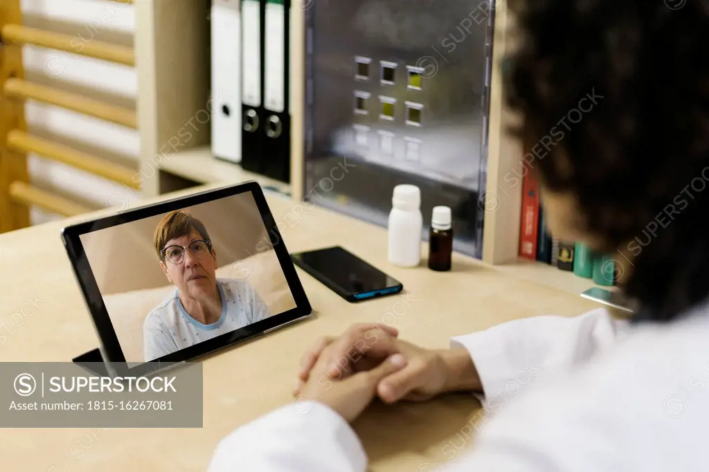 Senior woman on digital tablet screen during video call with doctor