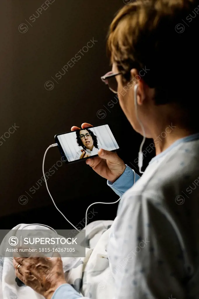 Elderly woman on video call with doctor while discussing at home