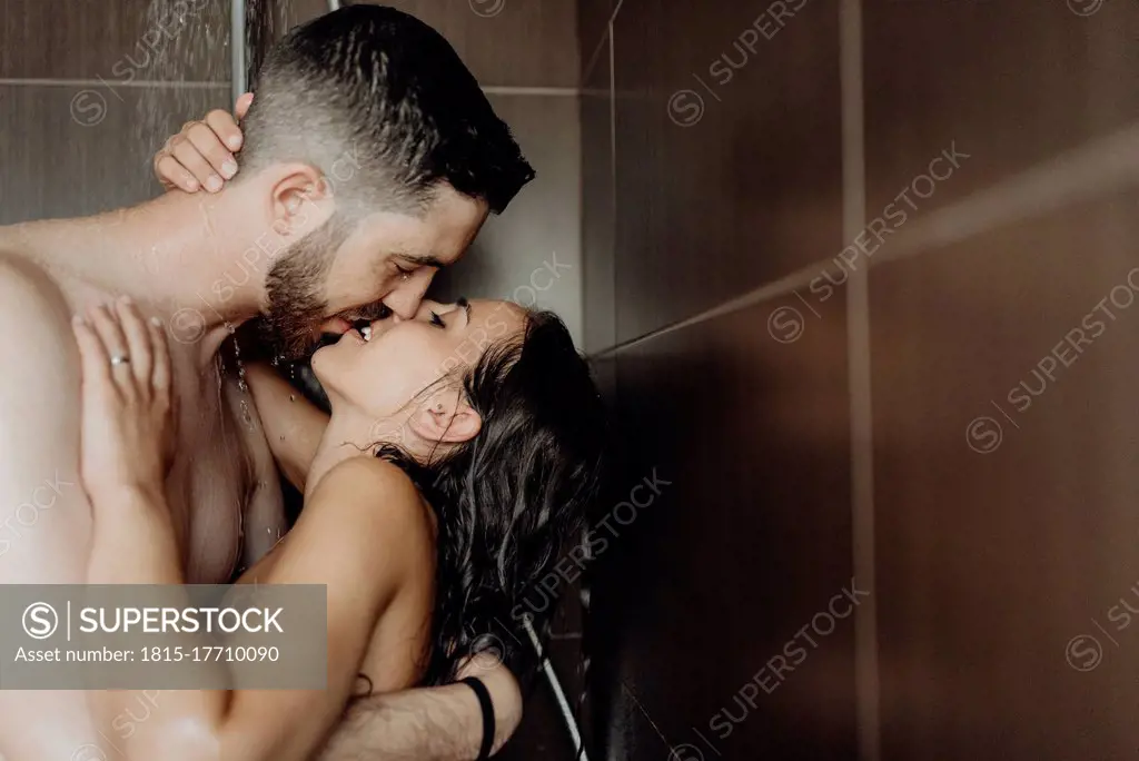 Naked romantic couple kissing each other on lips in bathroom
