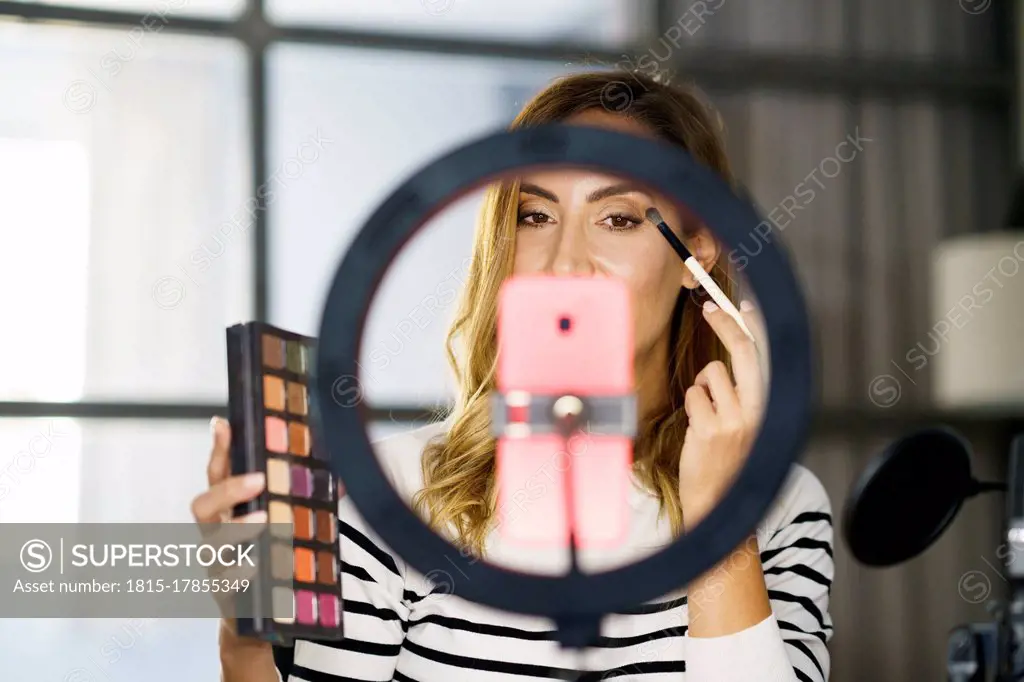 Woman teaching make-up on video call while sitting at home