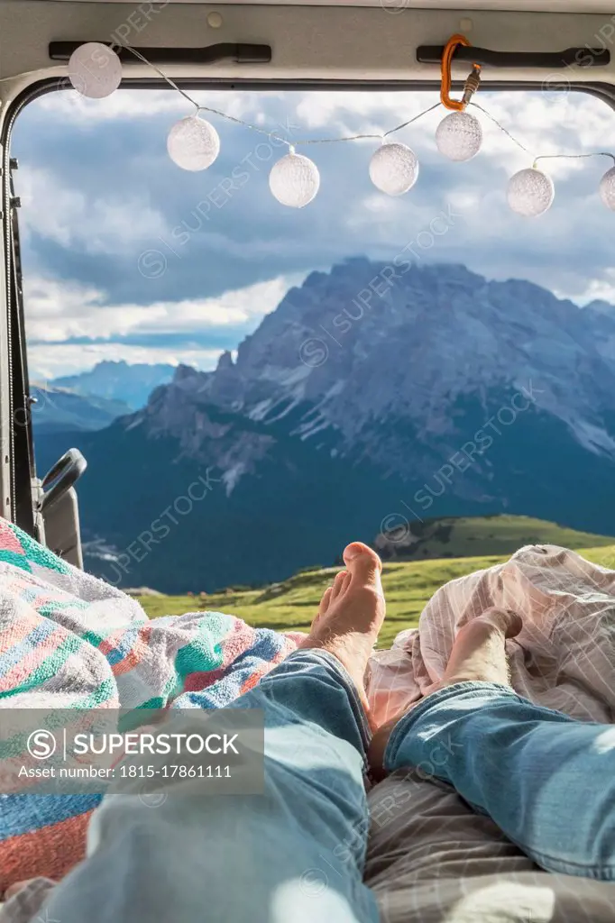 Man relaxing in campervan against mountain range, Sesto Dolomites, Dolomites, Alto Adige, Italy