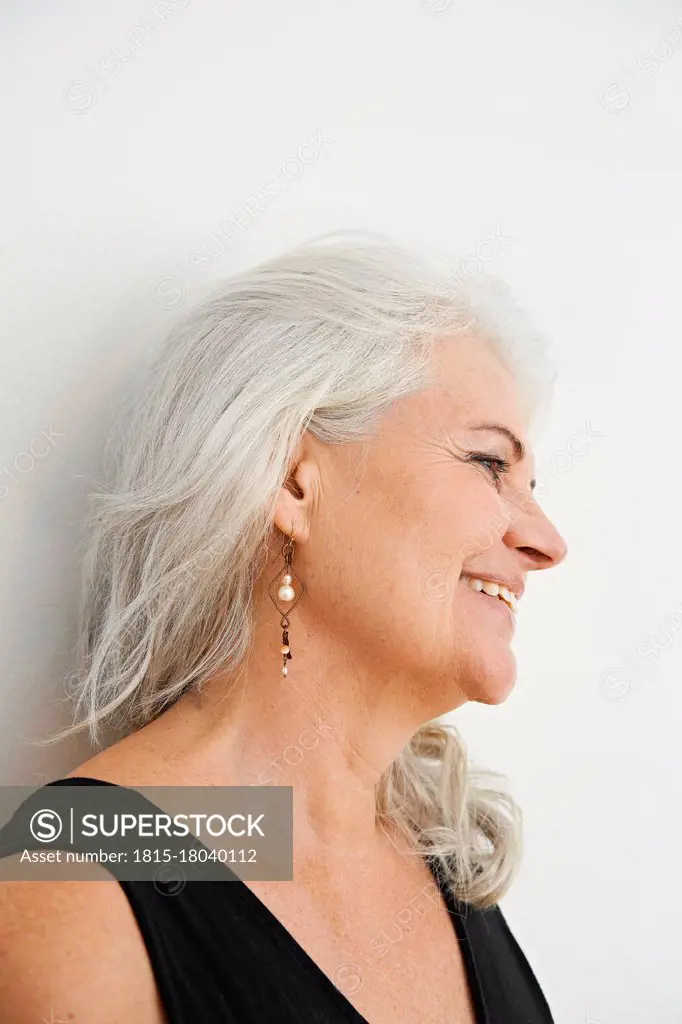 Smiling woman looking away against white background