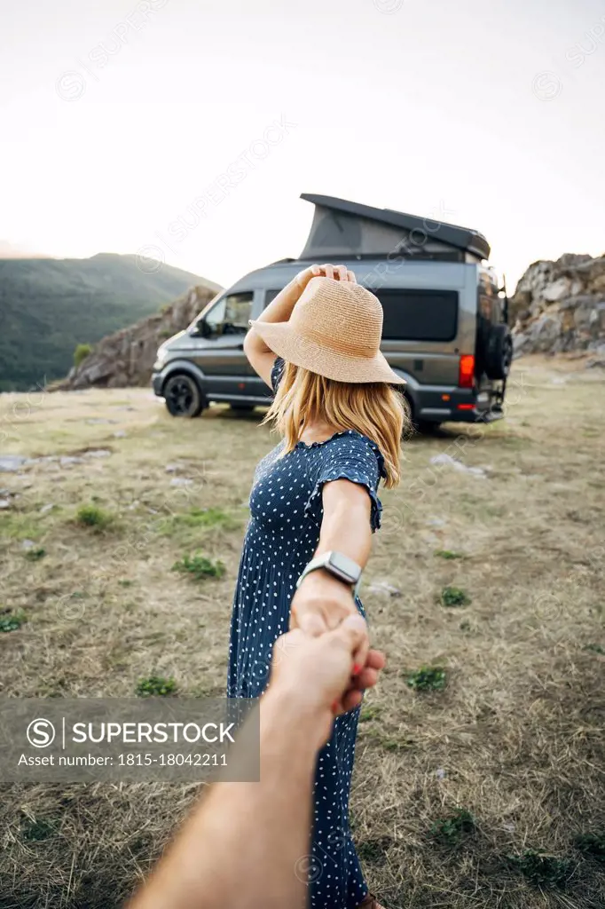 Woman holding hand of man while looking away on vacations