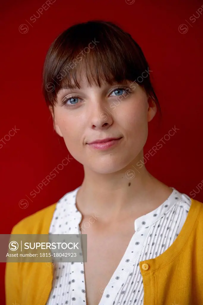 Confident female professional against red wall
