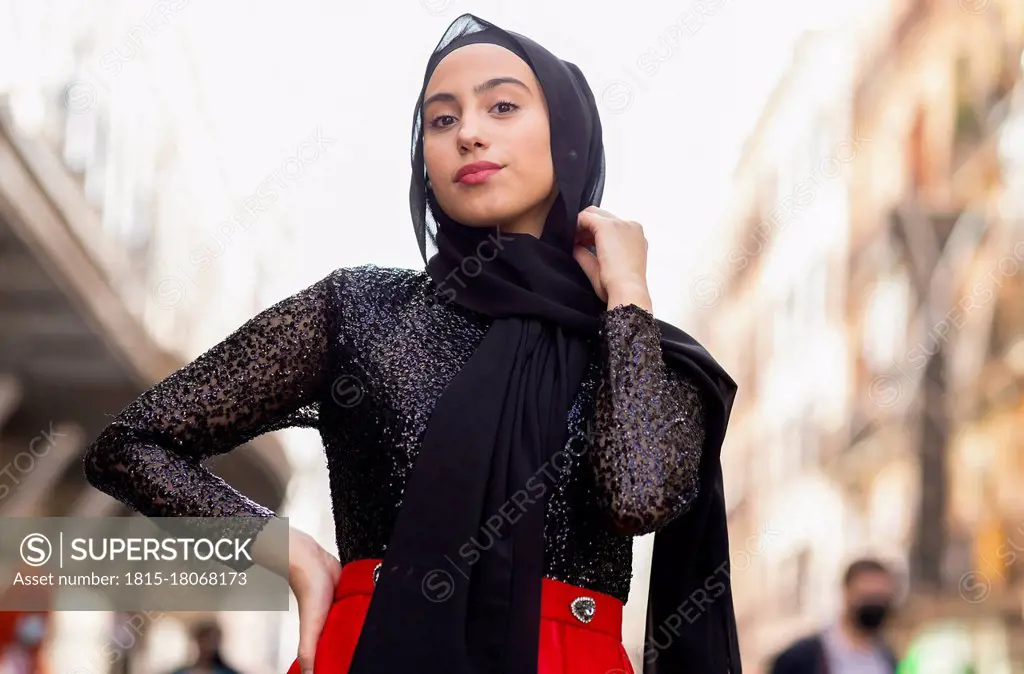 Portrait of young woman wearing black¶ÿhijab¶ÿposing outdoors with hand on hip